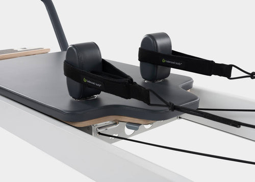 Close-up of the foot straps on a Balanced Body aluminum Pilates reformer.